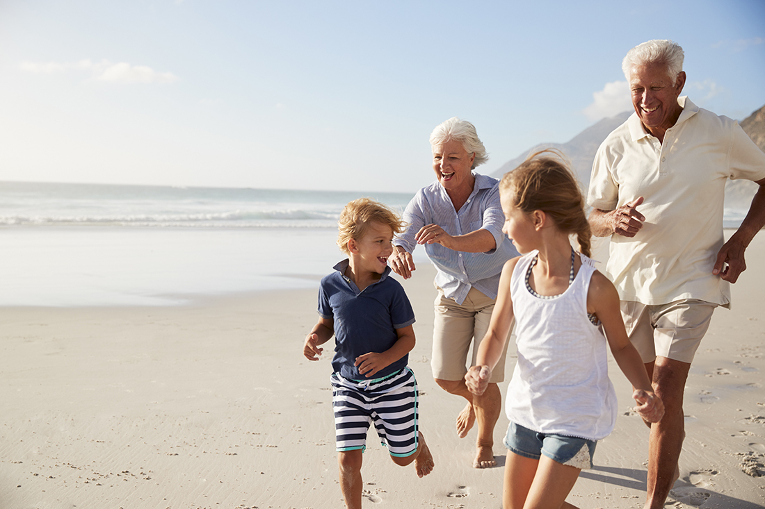 Grandparents and grandchildren enjoying a sunny day at the beach together